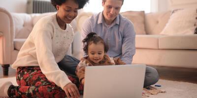 Jong gezin kijkt samen naar laptop