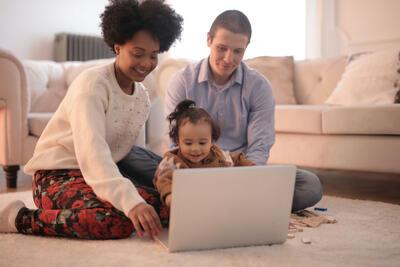 Jong gezin kijkt samen naar laptop